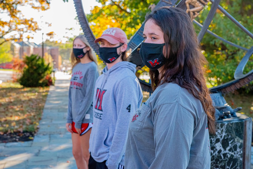 Three students wearing Miami University branded face masks.
