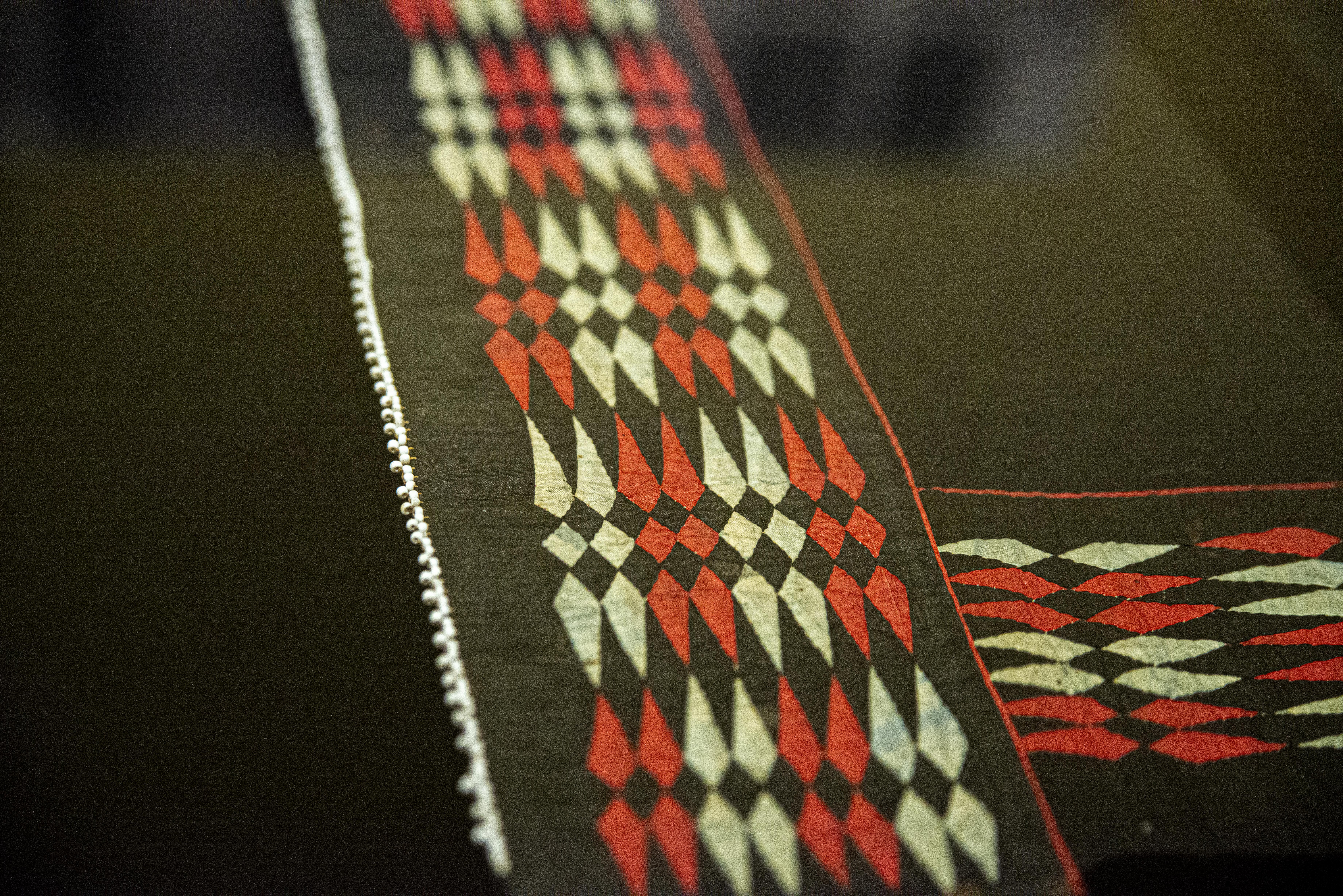 A close up of the ribbonwork and beading design on a pair of woman's leggings