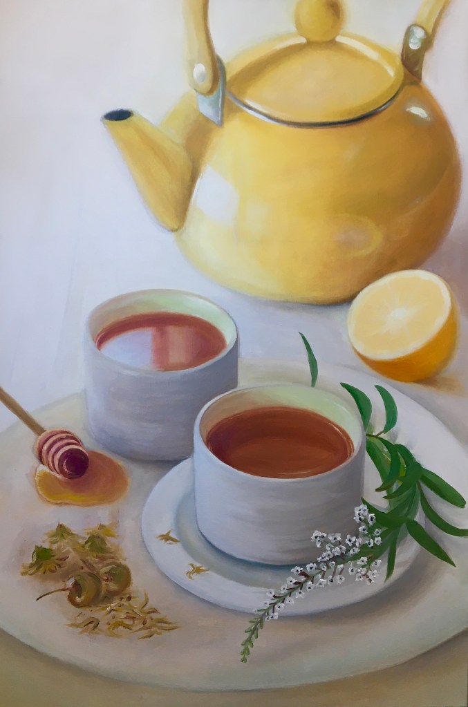 Cups of tea on a platter with a teapot and lemon in the background