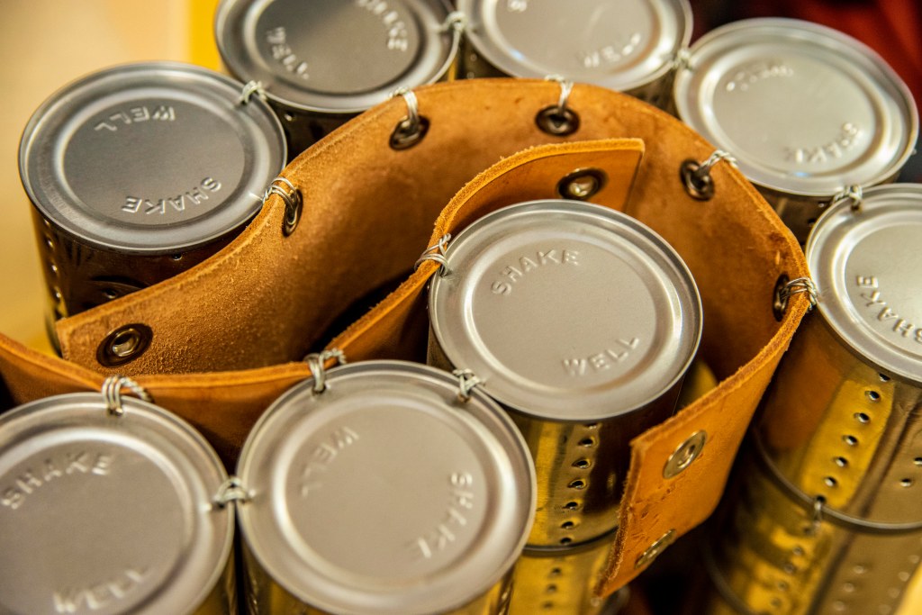 A closer view of how the tin cans are put together with leather to make shaker cans