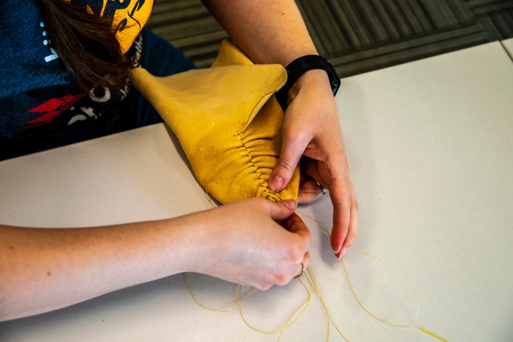 Participant sewing the puckers along the mahkisina top
