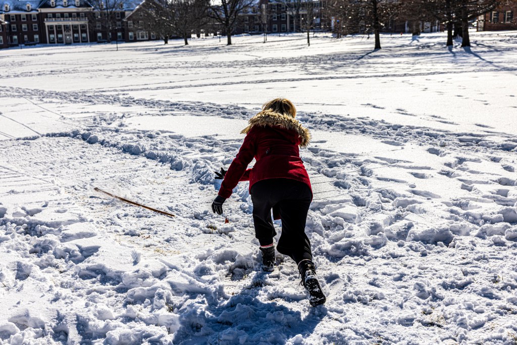 Myaamia Student throws snowsnake across the snow.