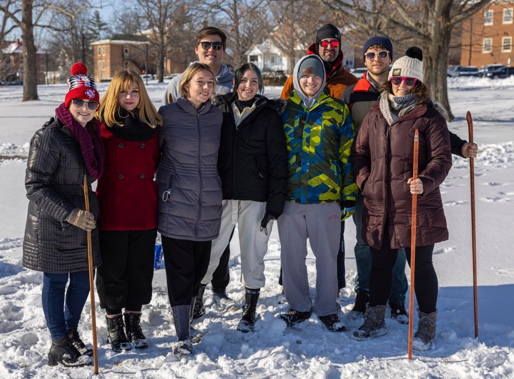 Several Myaamia Students and Myaamia Center staff posing together in the snow holding snowsnakes.