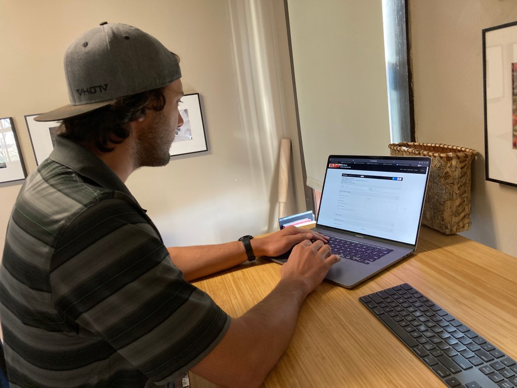 Adult typing on a laptop at a desk