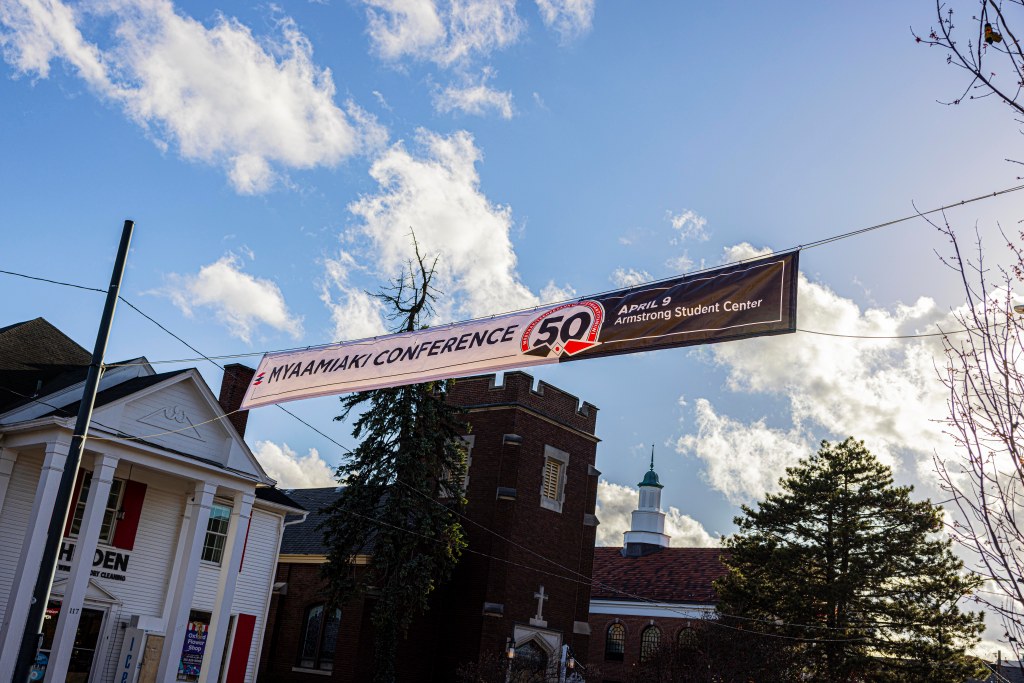 Banner advertising the Myaamiaki Conference above a street
