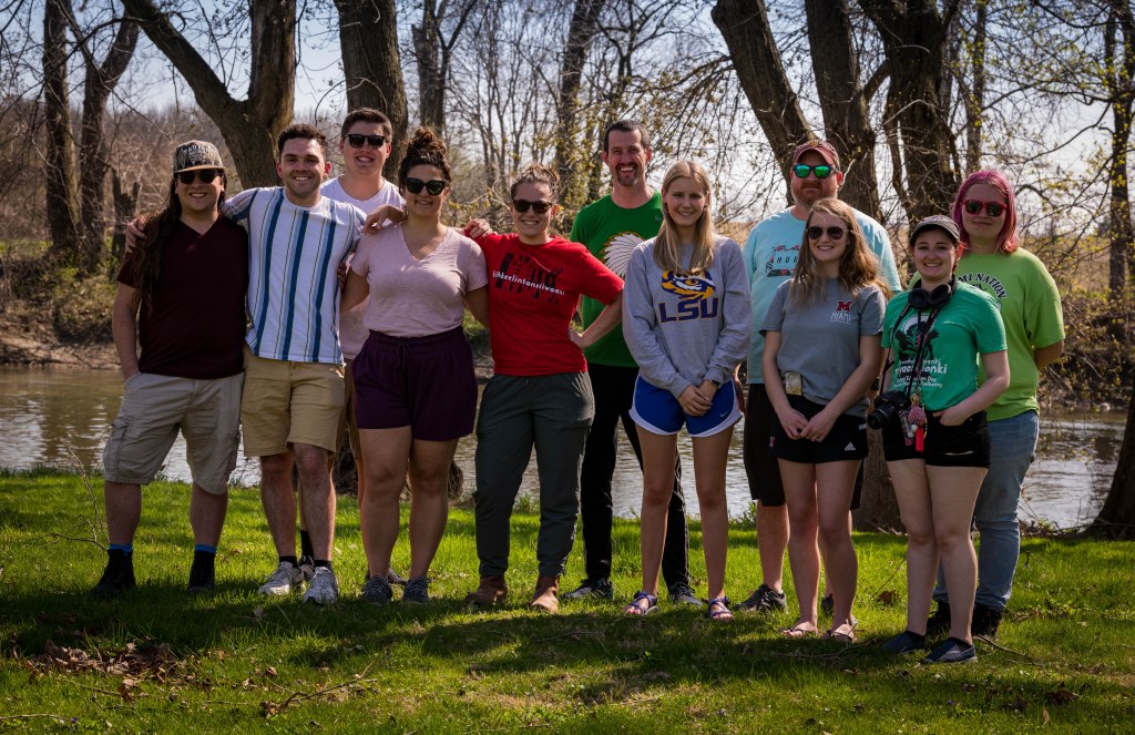 11 people standing together in front of the Wabash River.
