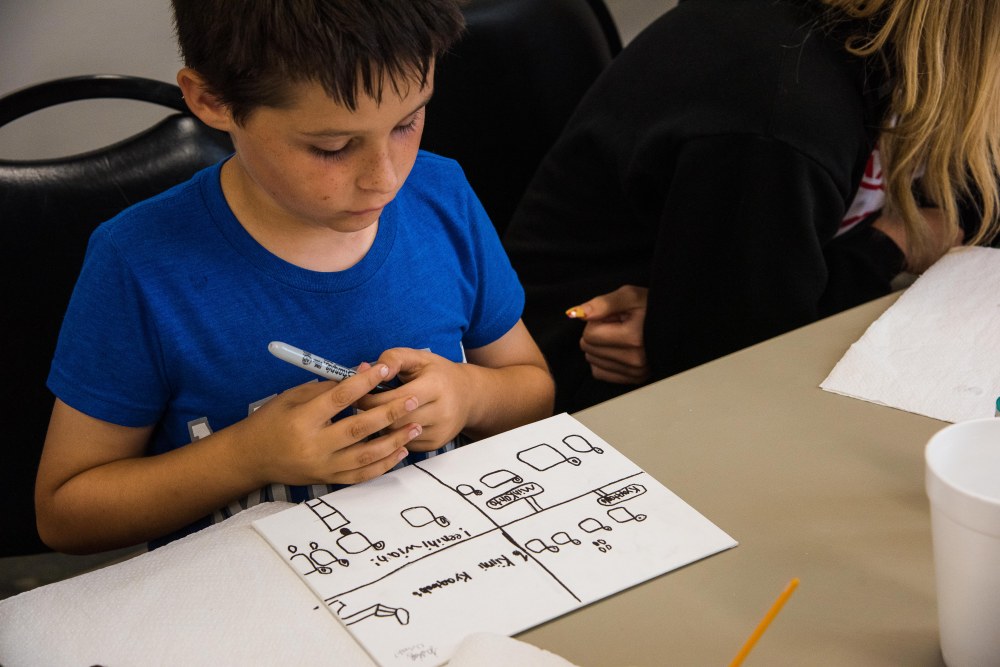 Person looking at a canvas with black ink drawings