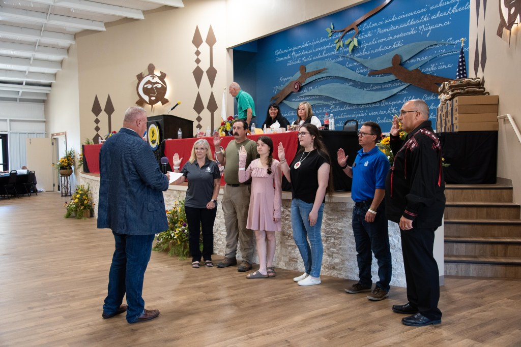 Six people raising their right hands as they are sworn into office.