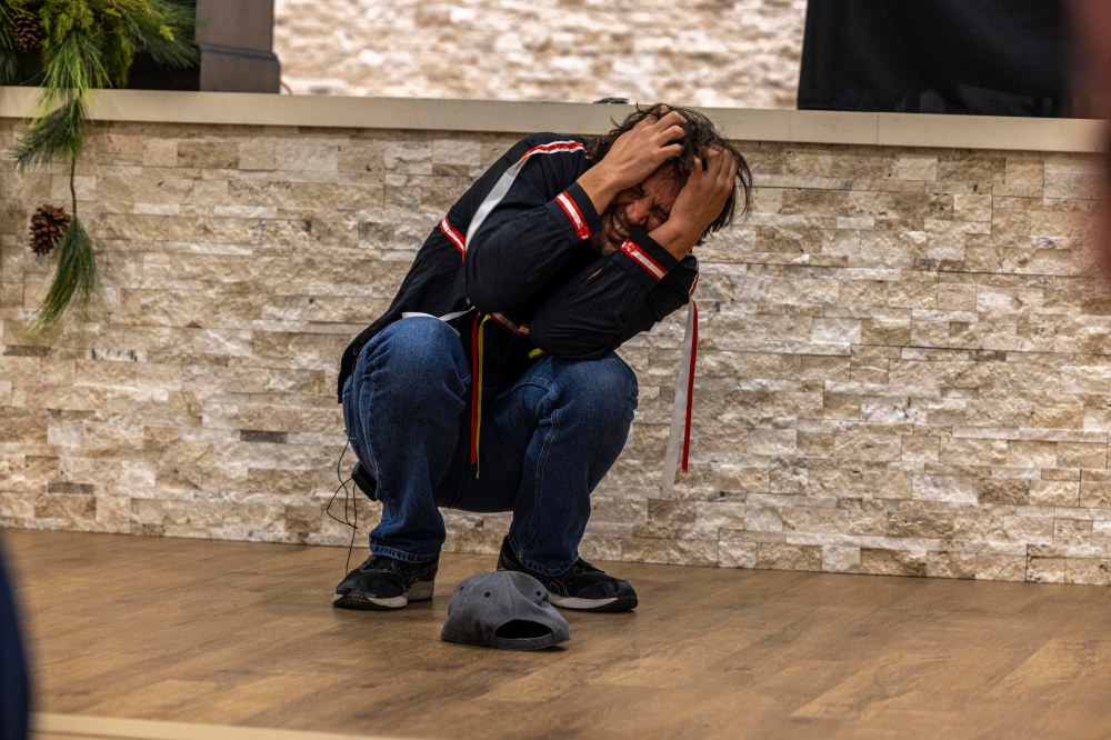 Man crouched down and covering his head