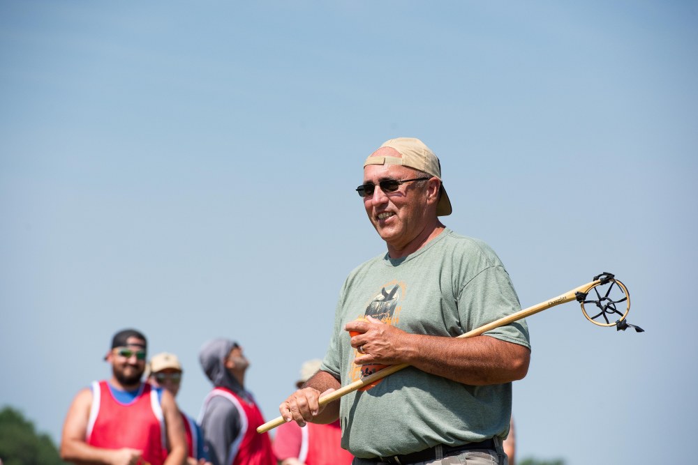 A man carrying his lacrosse stick