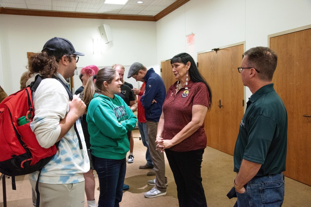 Two students have a conversation with two of the Miami Tribe's elected leadership