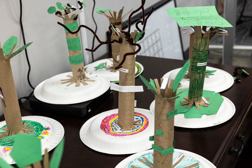 A table full of trees crafted from cardboard, paper, and pipecleaners.