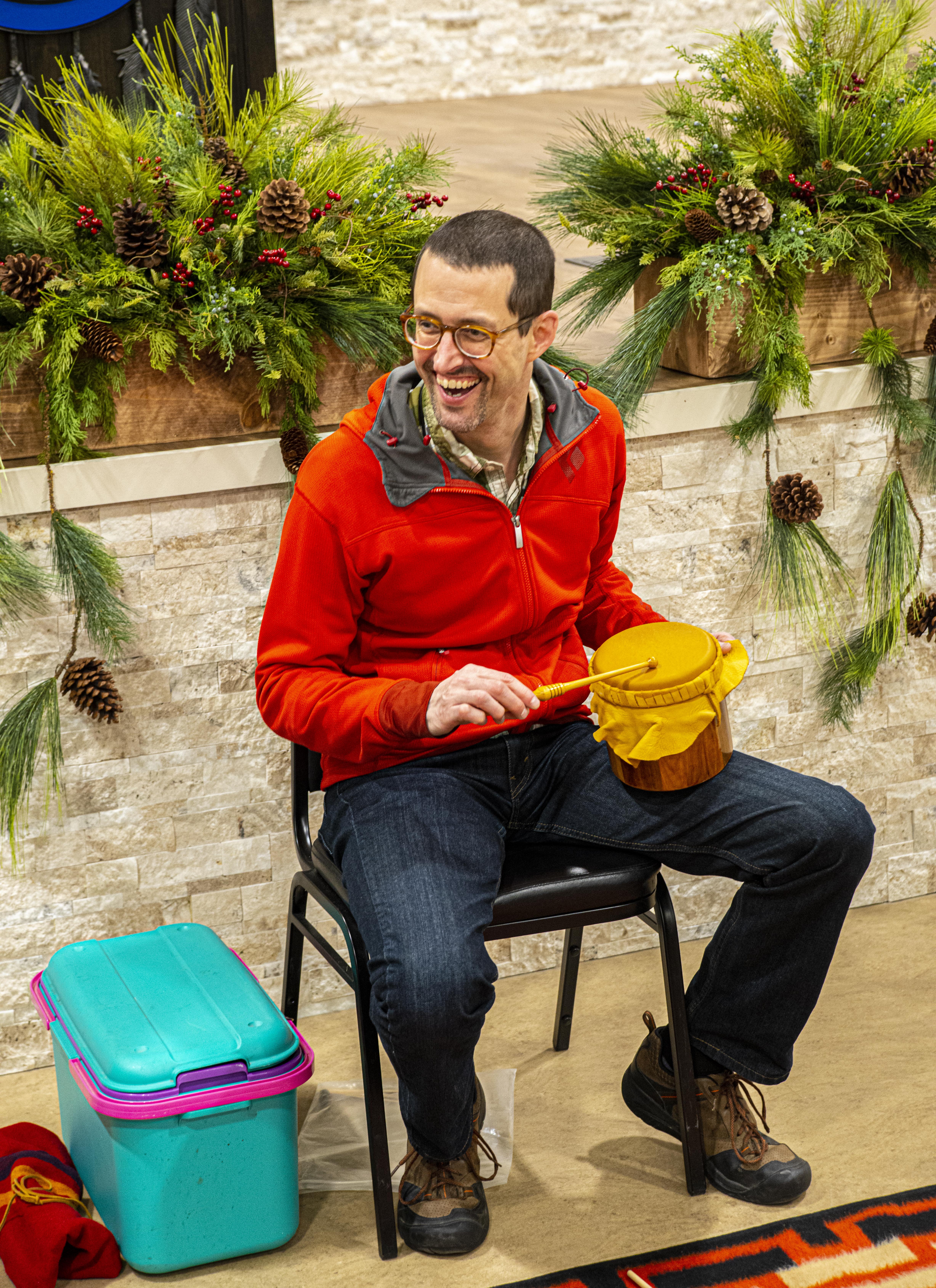 George sits in a chair holding a small drum