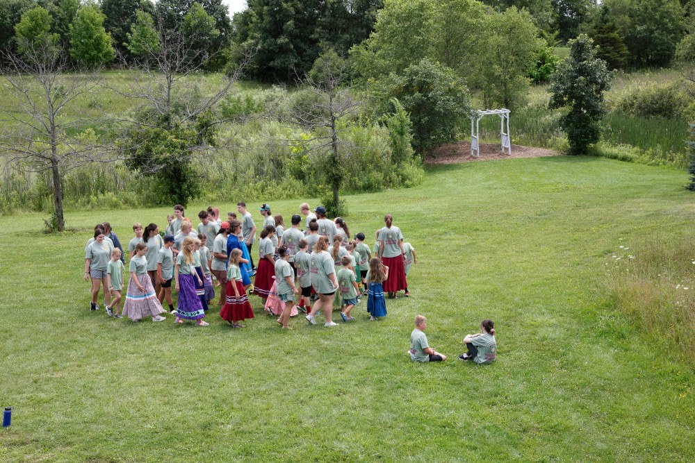 Youth participants stomp dance outside