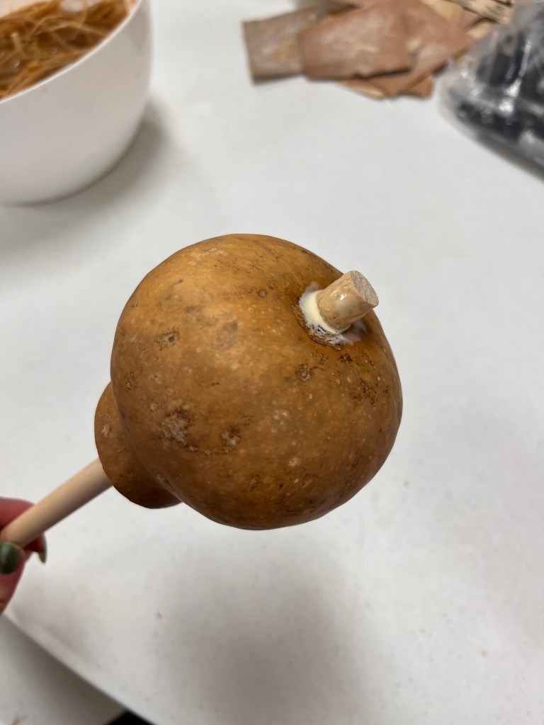 The gourd is attached to the dowel rod with wood glue