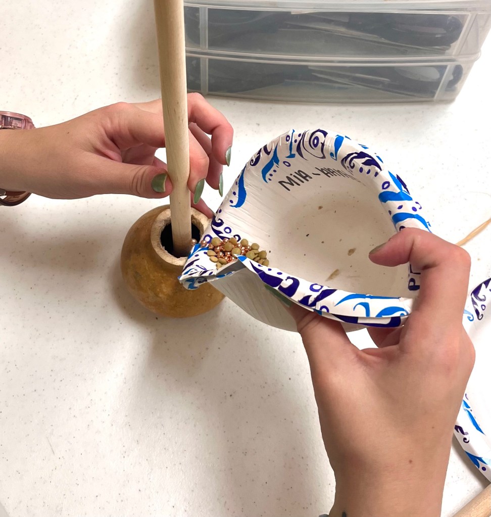 Pouring BBs and lentils into the dried gourd
