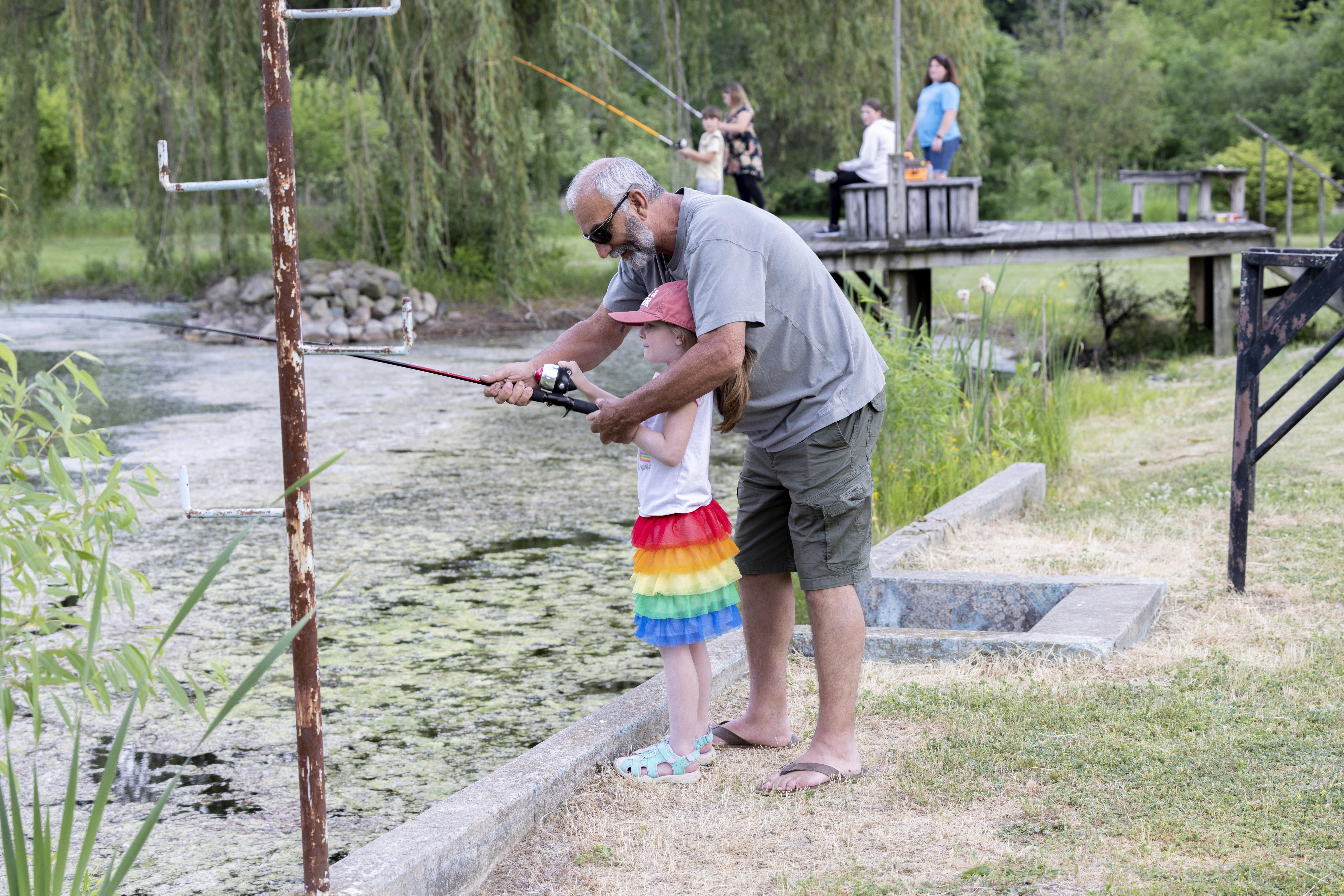 A Myaamia youth learns to fish with a community member