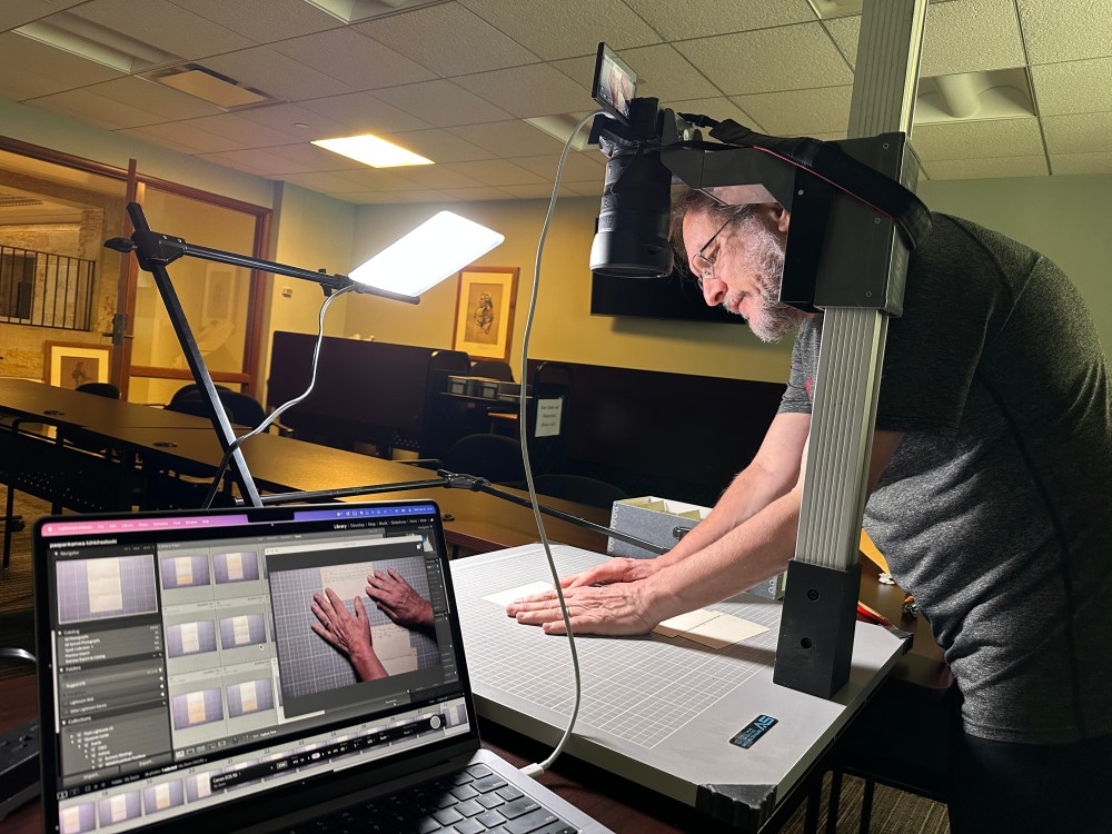 David arranges documents in front of a camera