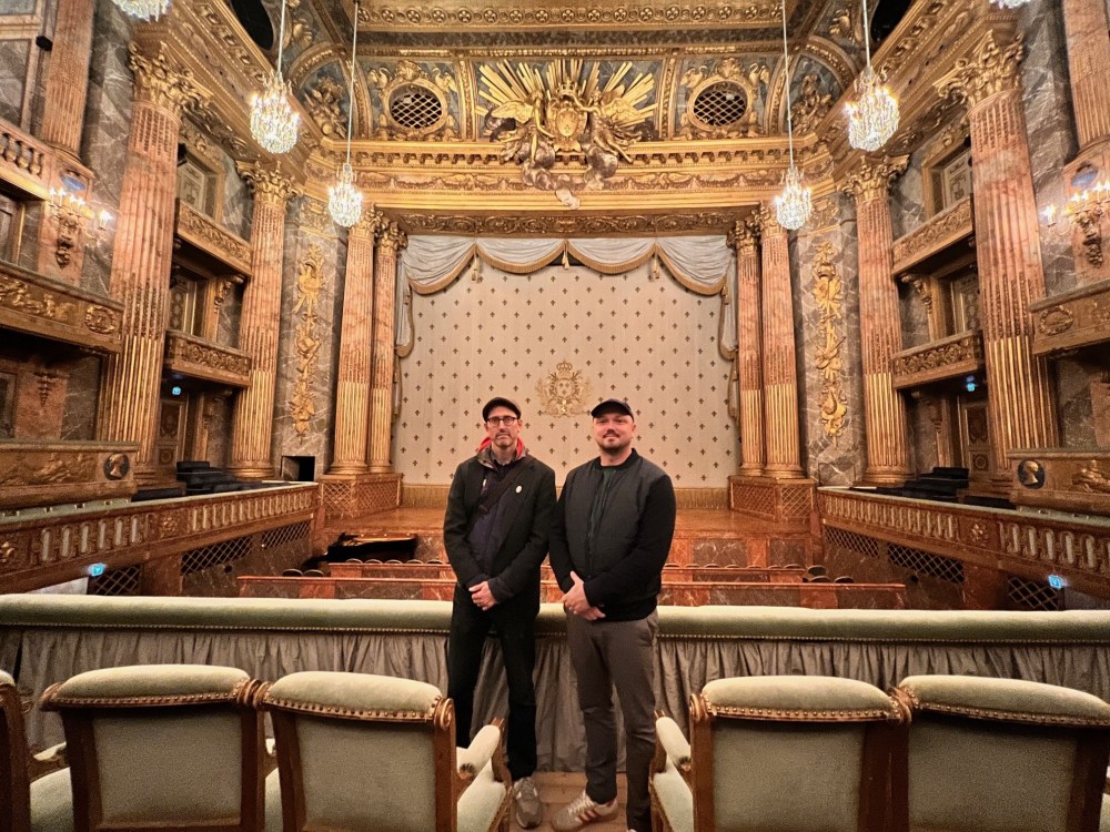 George Ironstrack and Nate Poyfair stand in the theatre of the palace