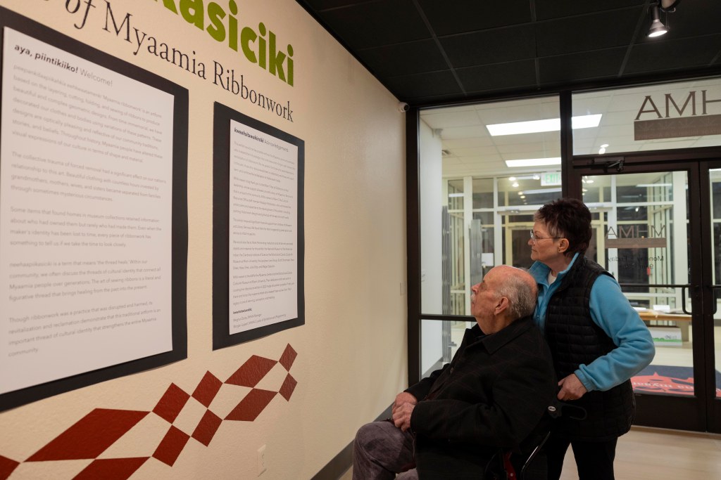 Two people read the exhibit info