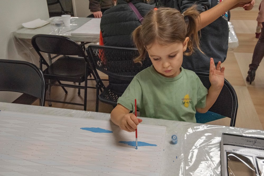 A young Myaamia person paints
