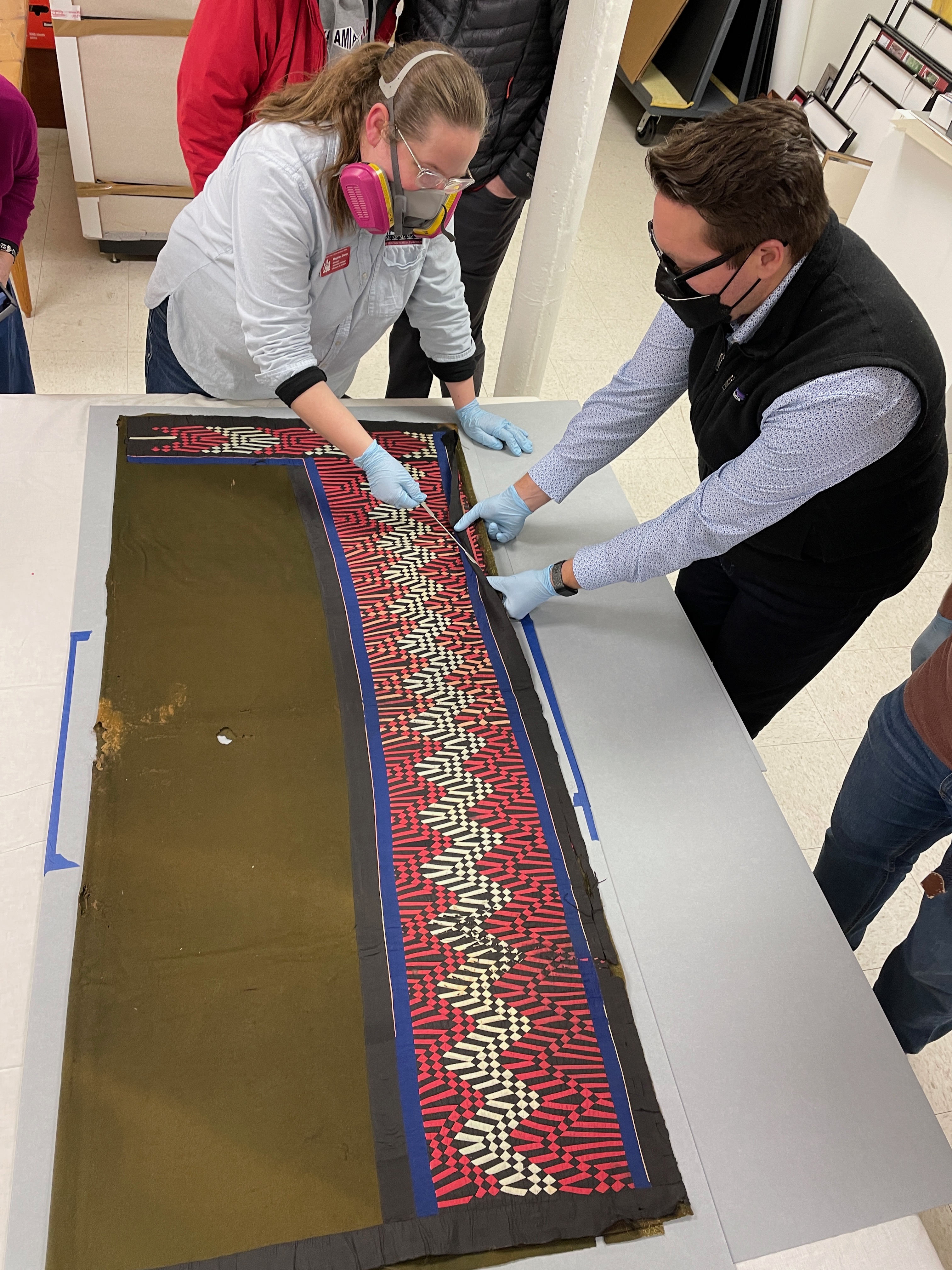 A man and woman carefully handle a blanket