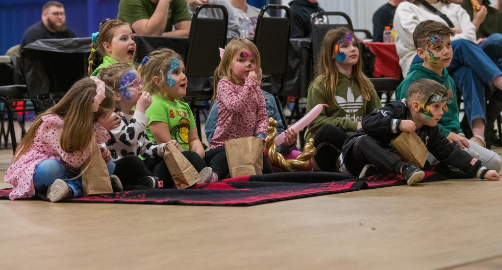 Young children are amazed by the magician's tricks