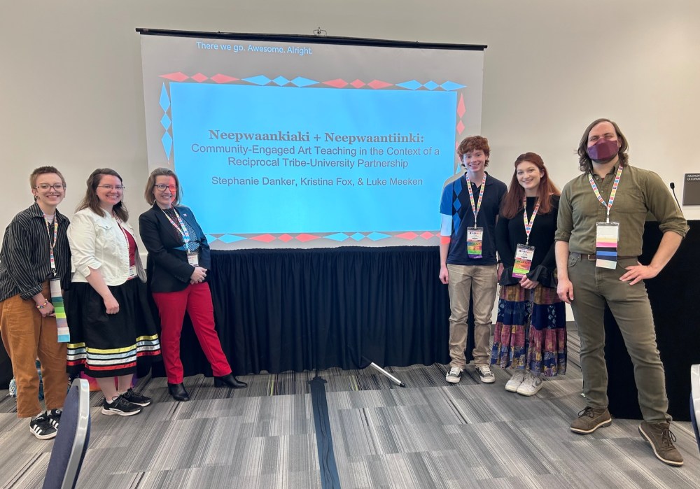 Presentation title slide centered between two groups of people