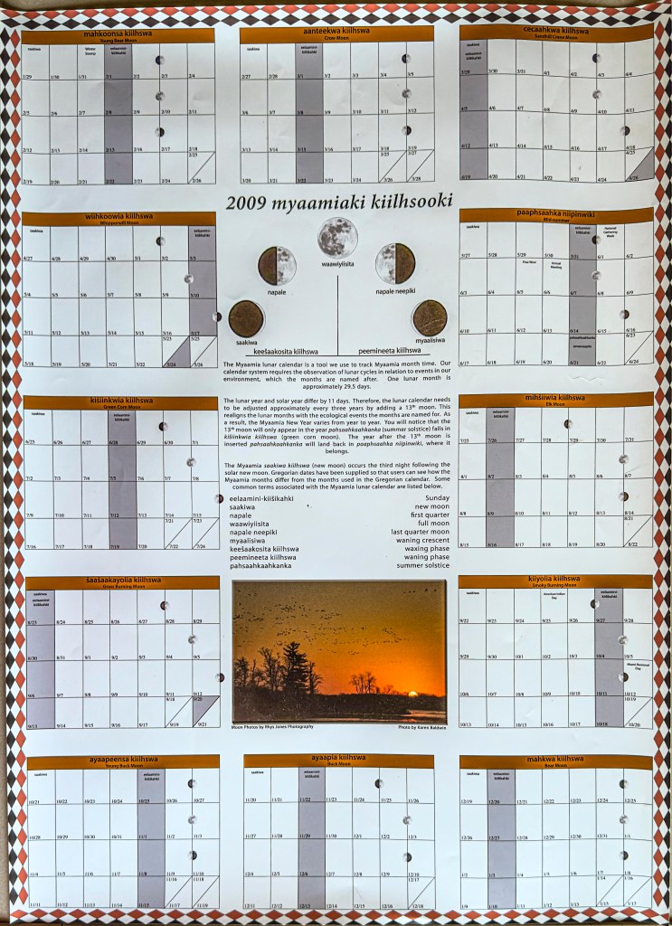 A large poster with 12 month date tables organized around the outside and information about the Myaamia lunar calendar system in the middle.